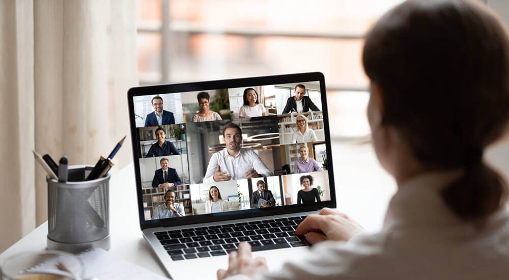 Back view of a man attending a virtual online training course on his laptop
